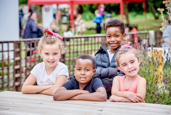 Four children sat at a table smiling at the camera.