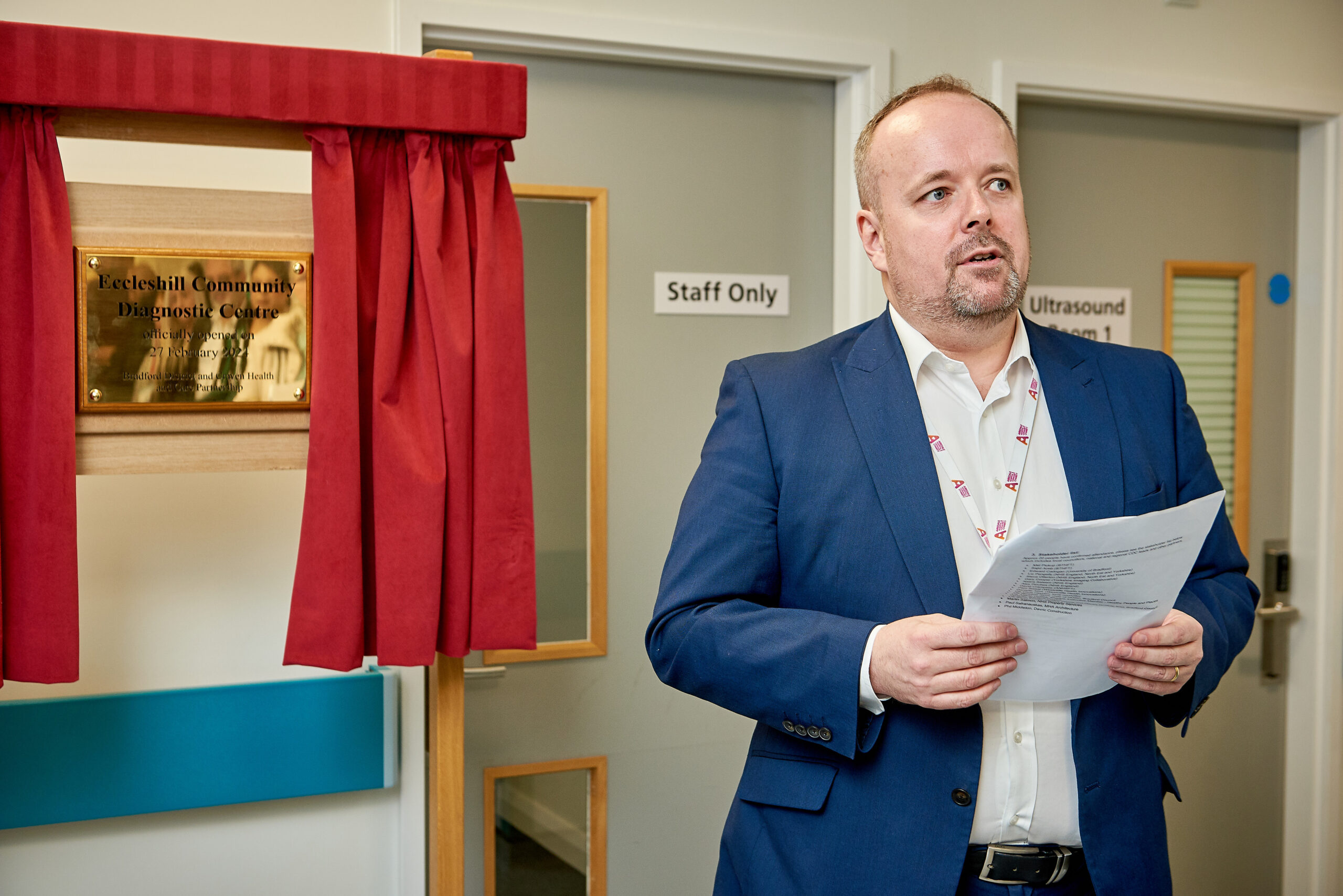 Picture of David Crampsey in front of Eccleshill Community Diagnostic Centre plaque.