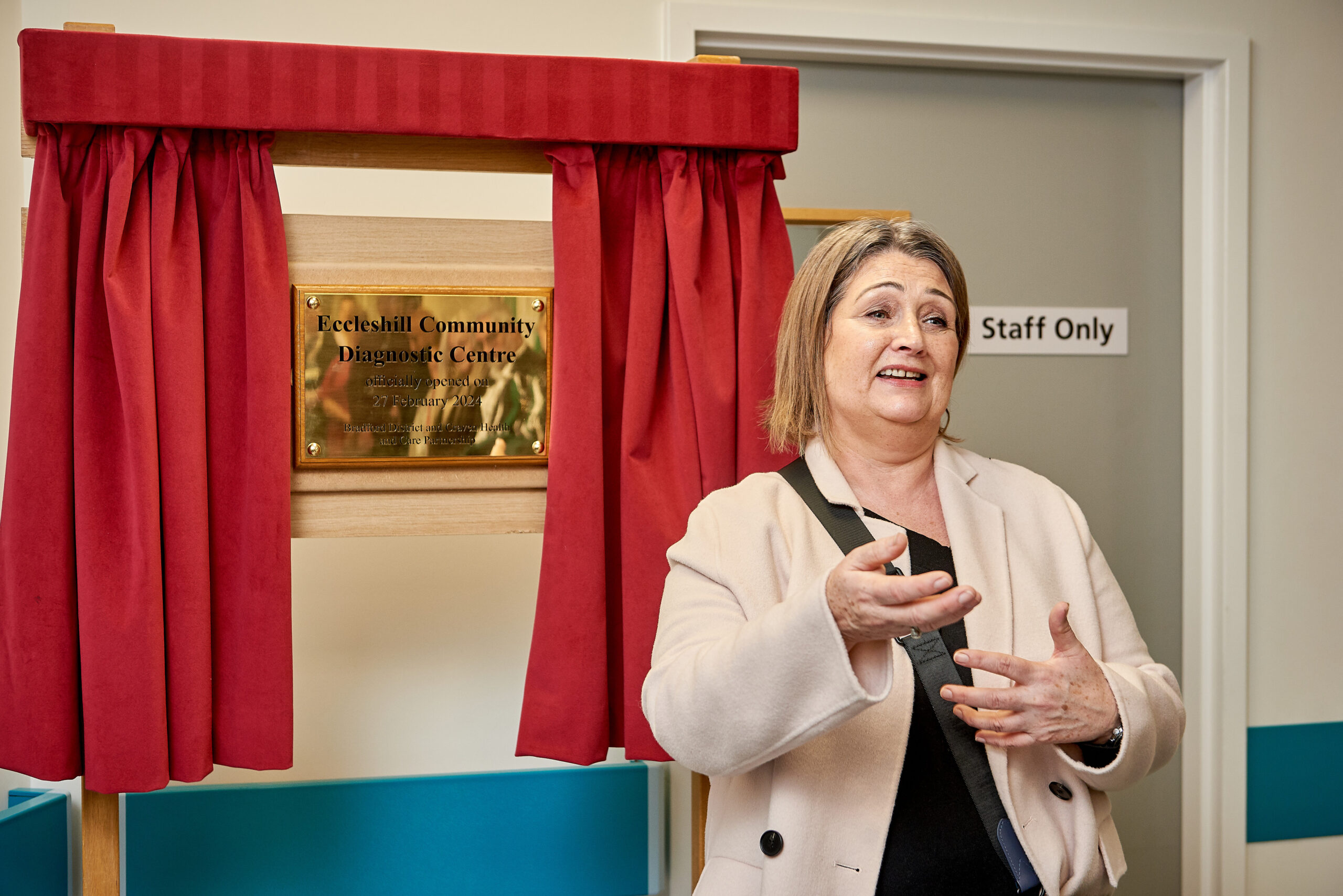 Picture of Alex Pinches in front of Eccleshill Community Diagnostic Centre plaque.