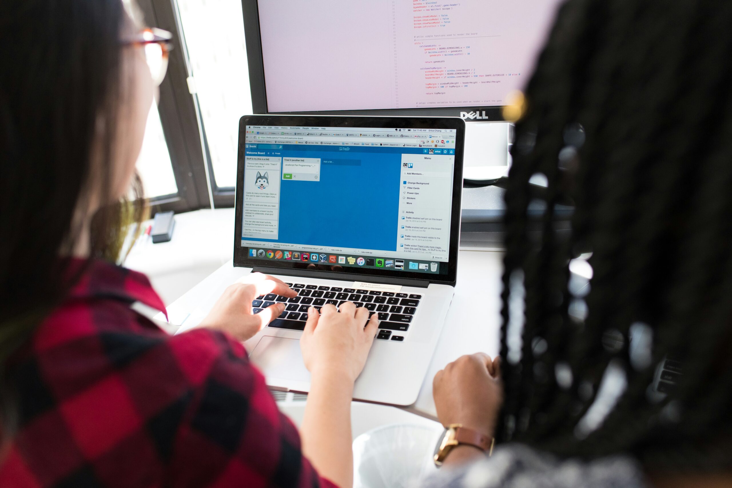 A picture of two people looking at a computer screen.